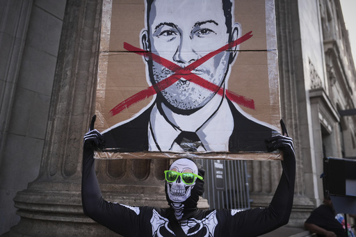 Asher Rogers holds an image of Jimmy Kimmel outside El Capitan Entertainment Centre, where the late-night show "Jimmy Kimmel Live!" is staged on Thursday, Sept. 18, 2025, in Los Angeles. (AP Photo/Jae C. Hong)