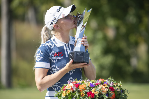 Charley Hull, of England, kisses the trophy after winning the Kroger Queen City Championship golf tournament, Sunday, Sept. 14, 2025, at TPC River's Bend in Cincinnati. (AP Photo/Tanner Pearson)