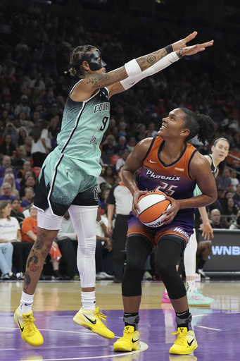 New York Liberty guard Natasha Cloud (9) defends against a shot by Phoenix Mercury forward Alyssa Thomas (25) during the first half of Game 3 in the first round of the WNBA basketball playoffs, Friday, Sept. 19, 2025, in Phoenix. (AP Photo/Rick Scuteri)