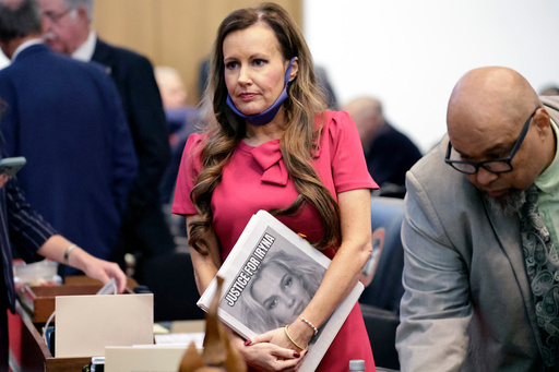 Rep. Tricia Cotham, R-Mecklenburg, center, holds a "Justice for Iryna" notebook before she introduces a bill in response to the murder of Ukrainian Iryna Zarutska during a North Carolina legislative session, Tuesday, Sept. 23, 2025, in Raleigh, N.C. (AP Photo/Chris Seward)