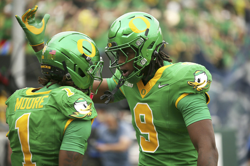 Oregon wide receiver Dakorien Moore (1) is congratulated after his touchdown by tight end Jamari Johnson (9) during the first half of an NCAA college football game against Oklahoma State, Saturday, Sept. 6, 2025, in Eugene, Ore. (AP Photo/Lydia Ely)
