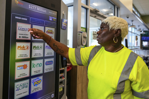 Roslyn Jefferson makes her lottery ticket selections on a self-serve terminal inside a gas station ahead of Saturday's Powerball drawing offering of $1 billion, Friday, Aug. 29, 2025, in Baltimore. (AP Photo/Stephanie Scarbrough)