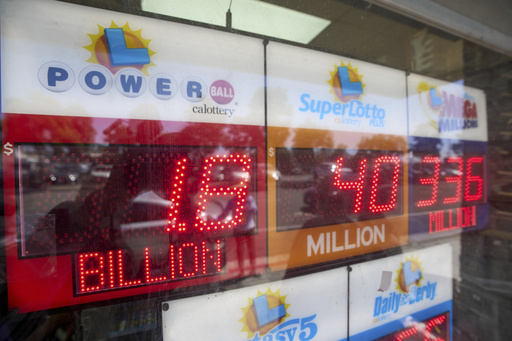 An electronic sign reads $1.8 billion as crowds wait in line to buy lottery tickets at the Bluebird Liquor store in Hawthorne, Calif., on Friday, Sept. 5, 2025. (AP Photo/Damian Dovarganes)