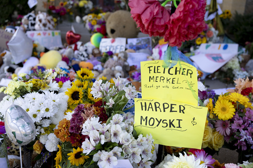 A sign honors the two victims who died in Wednesday's shooting, 8-year-old Fletcher Merkel and 10-year-old Harper Moyski, outside Annunciation Catholic Church, Sunday, Aug. 31, 2025, in Minneapolis. (AP Photo/Ellen Schmidt)
