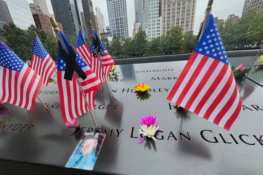 Flags and flowers are placed in the inscribed names at the National September 11 Memorial in New York on Wednesday, Sept. 10, 2025. (AP Photo/Donald King)