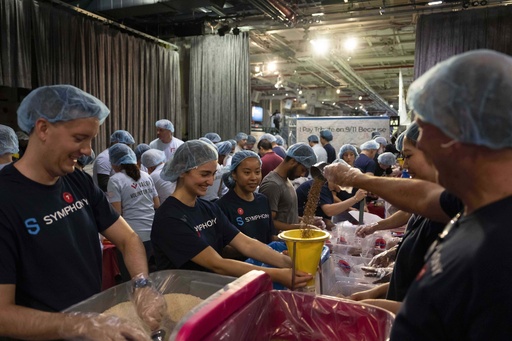 Volunteers work during the "NYC Meal Pack For 9/11 Day" at the Intrepid Sea, Air & Space Museum, Wednesday, Sep. 10, 2025, in New York. (AP Photo/Yuki Iwamura)