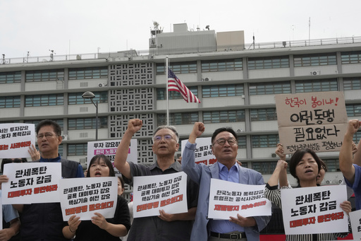 Protesters stage a rally against the detention of South Korean workers during an immigration raid in Georgia, near the U.S. Embassy in Seoul, South Korea, Tuesday, Sept. 9, 2025. The signs read "A tariff bomb and workers confinement." (AP Photo/Ahn Young-joon)