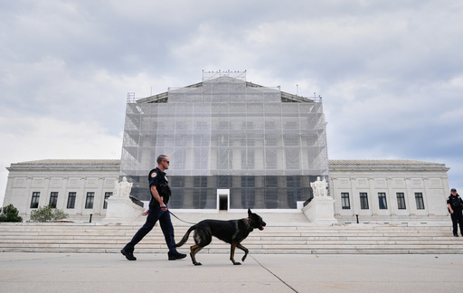 U.S. Capitol Police officers with a K9 detector dog, patrols outside of Supreme Court, Wednesday, Sept. 24, 2025, in Washington. (AP Photo/Mariam Zuhaib)