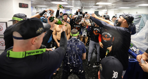 The Detroit Tigers celebrate in the locker room after defeating the Boston Red Sox and clinching a spot in the playoffs, Saturday, Sept. 27, 2025, in Boston. (AP Photo/Mark Stockwell)