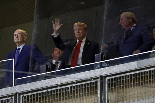 President Donald Trump, center, gestures next to New York Yankees president Randy Levine, front right, during the seventh inning of a baseball game against the Detroit Tigers, Thursday, Sept. 11, 2025, in New York. (AP Photo/Adam Hunger)