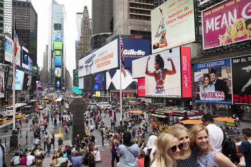 FILE - In this June 20, 2019, file photo, tourists visit Times Square in New York. (AP Photo/Mark Lennihan, File)