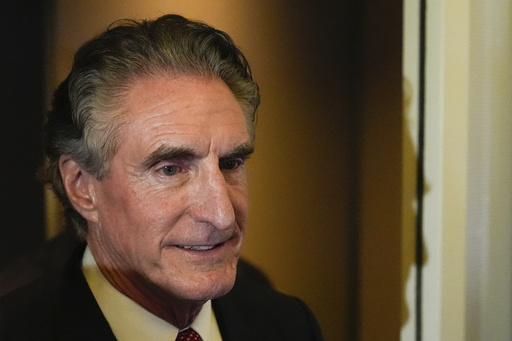 Interior Secretary Doug Burgum watches as President Donald Trump speaks to reporters aboard Air Force One while en route to Joint Base Andrews, Md. after attending a memorial for conservative activist Charlie Kirk in Glendale, Ariz., Sunday, Sept. 21, 2025. (AP Photo/Julia Demaree Nikhinson)