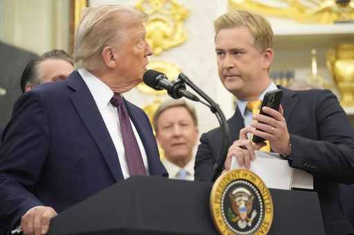 FOX News reporter Peter Doocy shows President Donald Trump a photo on his phone during an event about the relocation of U.S. Space Command headquarters from Colorado to Alabama in the Oval Office of the White House, Tuesday, Sept. 2, 2025, in Washington. (AP Photo/Mark Schiefelbein)