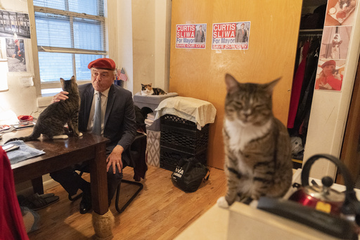 FILE - New York City Republican mayoral candidate Curtis Sliwa pets one of his cats as he speaks during an interview with The Associated Press in his apartment, Tuesday, Oct. 12, 2021, in New York. (AP Photo/Mary Altaffer, file)