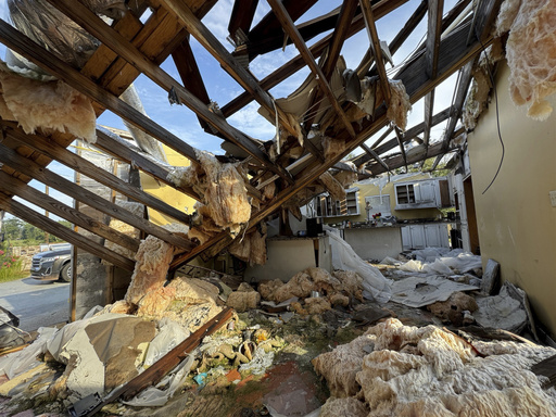 A collapsed roof and insulation cover what used to be Buddy Anthony's kitchen on Thursday, Aug. 14, 2025, in Tylertown, Miss. (AP Photo/Sophie Bates)