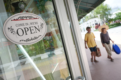 Shoppers walk by a clothing store, Thursday, Sept. 25, 2025, in Miami Beach, Fla. (AP Photo/Marta Lavandier)