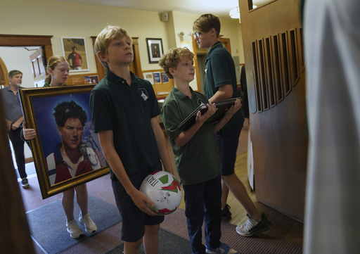 Students of St. John Berchmans' school hold items often linked to Blessed Carlo Acutis, who will be canonized a saint by Pope Leo XIV, before Mass at Blessed Carlo Acutis Parish, on Wednesday, Sept. 3, 2025, in Chicago. (AP Photo/Jessie Wardarski)