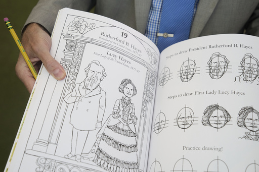 John Hutton, illustrator and professor of art history at Salem College, holds open his book, "How To Draw The Presidents and First Ladies," Tuesday, Aug. 12, 2025, at The People's House, a museum in Washington. (AP Photo/Jacquelyn Martin)