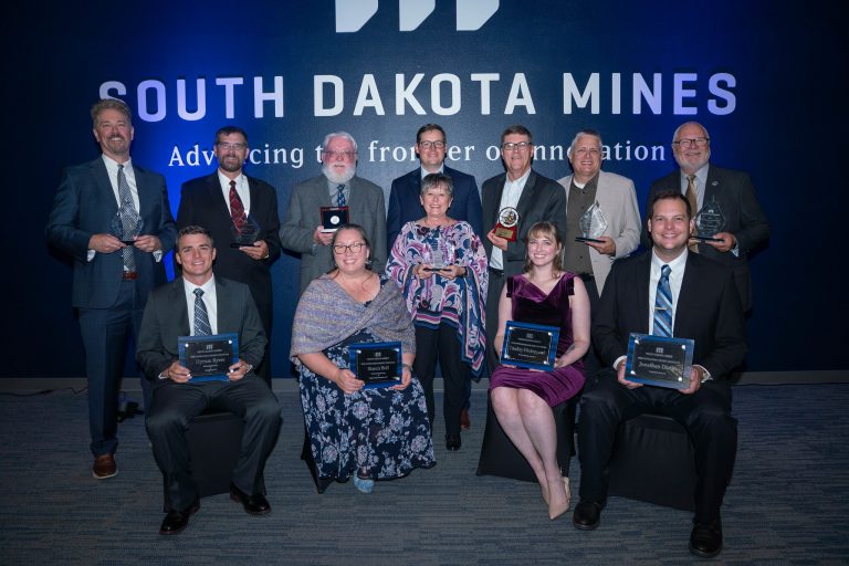Award winners at the Hardrocker Heritage Gala at South Dakota Mines were honored for their dedication and innovation recently. Back row, left to right: John Konechcne, Terry Rasmussen, Jim Green, President Brian Tande, Ken Miller, Chad Glanzer, Dr. James Rankin Front row, left to right: Hyrum Byers, Bianca Boll, Connie Green, Lindsey Westergaard, Jonathan Dixon