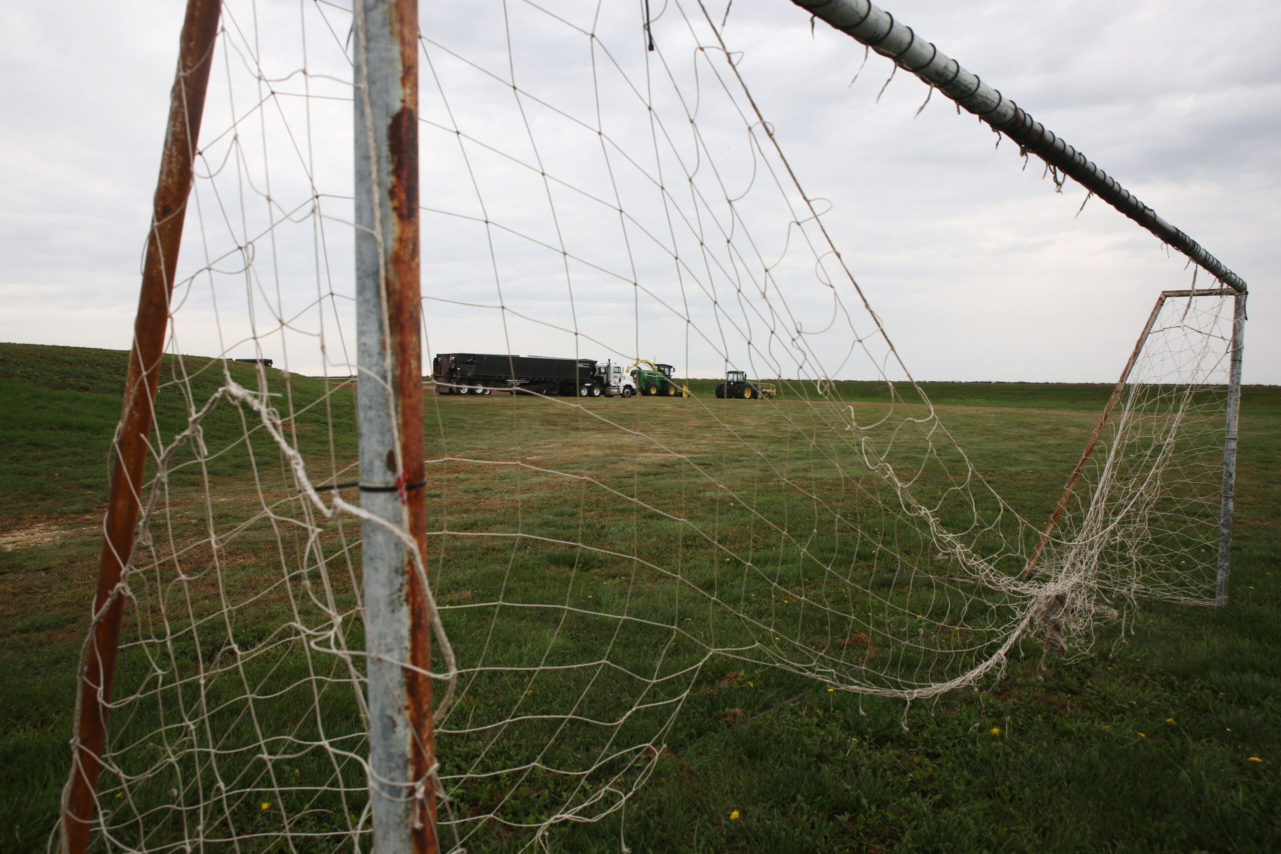 A torn soccer goal stands in front of the Drumgoon Dairy office and near tractors on the operation on Sept. 17, 2025 near Lake Norden. (Makenzie Huber/South Dakota Searchlight)