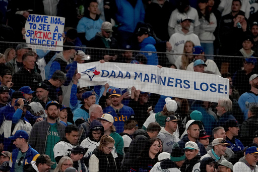 Toronto Blue Jays fans hold signs during the eighth inning in Game 3 of baseball's American League Championship Series against the Seattle Mariners, Wednesday, Oct. 15, 2025, in Seattle. (AP Photo/Lindsey Wasson)