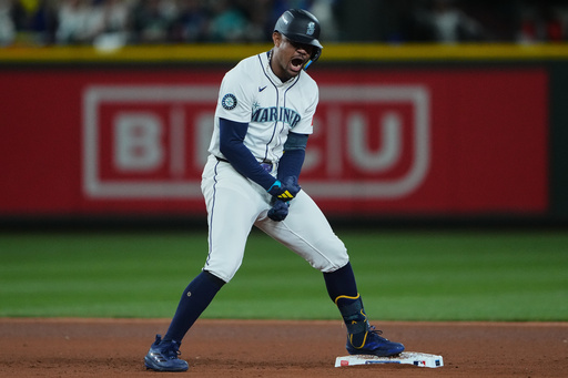Seattle Mariners' Julio Rodriguez reacts after hitting a double to score Cal Raleigh for the go-ahead run during the eighth inning in Game 2 of baseball's American League Division Series against the Detroit Tigers, Sunday, Oct. 5, 2025, in Seattle. (AP Photo/Lindsey Wasson)
