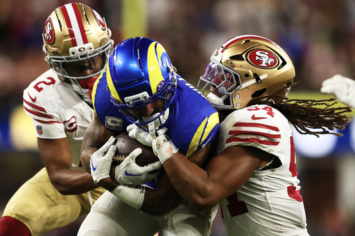 Los Angeles Rams running back Kyren Williams, middle, runs against San Francisco 49ers cornerback Deommodore Lenoir, left, and middle linebacker Fred Warner (54) during the second half of an NFL football game, Thursday, Oct. 2, 2025, in Inglewood, Calif. (AP Photo/Jessie Alcheh)