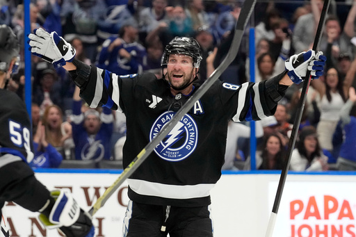Tampa Bay Lightning right wing Nikita Kucherov (86) celebrates after picking up assist for his 1,000th career point on a goal by center Brayden Point during the second period of an NHL hockey game against the Anaheim Ducks Saturday, Oct. 25, 2025, in Tampa, Fla. (AP Photo/Chris O'Meara)