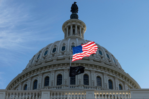 The American flag over the Capitol is illuminated by the early morning light on the first day of a government shutdown, in Washington, Wednesday, Oct. 1, 2025. (AP Photo/J. Scott Applewhite)