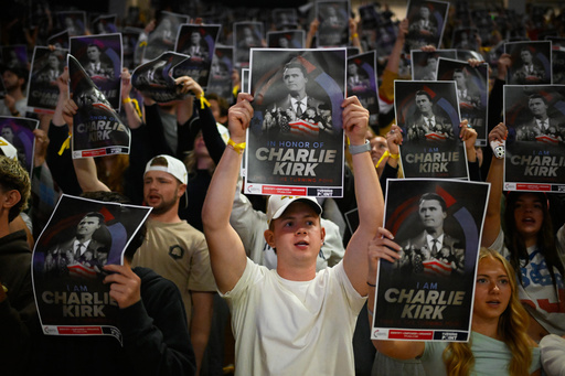 People hold posters of Charlie Kirk during a Turning Point USA rally at Utah State University, as a part of the organization's push to memorialize Kirk, Tuesday, Sept. 30, 2025, in Logan, Utah. (AP Photo/Alex Goodlett)