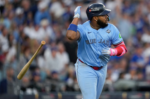 Toronto Blue Jays' Vladimir Guerrero Jr. flips his bat after hitting a two run against the Los Angeles Dodgers during the third inning in Game 4 of baseball's World Series, Tuesday, Oct. 28, 2025, in Los Angeles. (AP Photo/Ashley Landis)