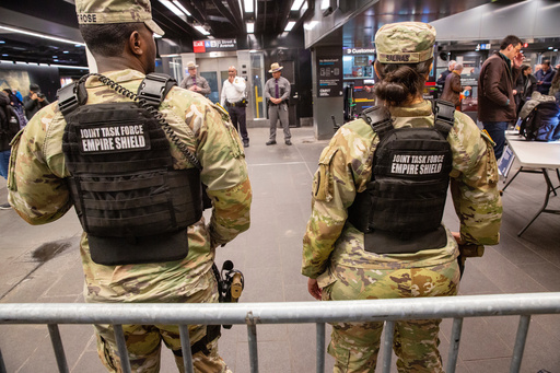 FILE - Members of the Armed Forces, including the National Guard, patrol the subway system in Penn Station as police officers check commuters' bags in New York on Thursday, March 7, 2024. (AP Photo/Ted Shaffrey, File)