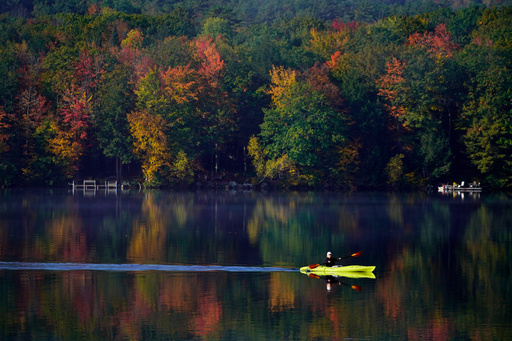FILE - Virginia Davidson of Bridgton, Maine, paddles her kayak on Moose Pond, Oct. 13, 2021, in Bridgton, Maine. (AP Photo/Robert F. Bukaty)