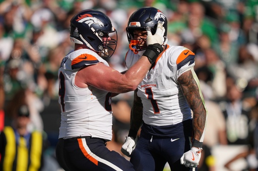 Denver Broncos tight end Evan Engram (1) celebrates his touchdown with Broncos offensive tackle Mike McGlinchey during the second half of an NFL football game against the Philadelphia Eagles on Sunday, Oct. 5, 2025, in Philadelphia. (AP Photo/Matt Slocum)