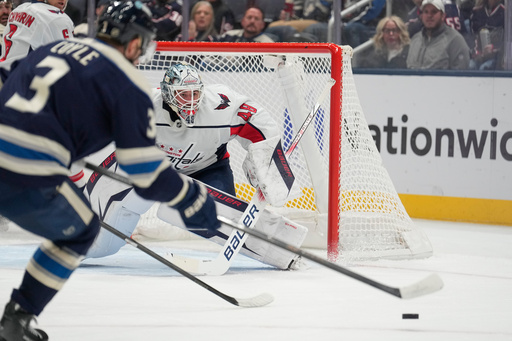 Columbus Blue Jackets center Charlie Coyle (3) skates in for a rebound in front of Washington Capitals goaltender Logan Thompson, right, in the first period of an NHL hockey game Friday, Oct. 24, 2025, in Columbus, Ohio. (AP Photo/Sue Ogrocki)