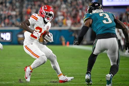 Kansas City Chiefs running back Brashard Smith (24) runs the ball under pressure from Jacksonville Jaguars cornerback Tyson Campbell (3) during the first half of an NFL football game, Monday, Oct. 6, 2025, in Jacksonville, Fla. (AP Photo/Phelan M. Ebenhack)