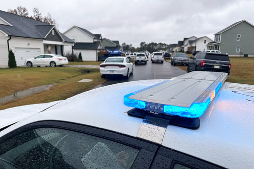 Law enforcement vehicles block the road to Wellington Delano Dickens III's home, where remains were found after Dickens told authorities he had killed four of his children, in Zebulon, N.C., on Tuesday, Oct. 28, 2025. (AP Photo/Allen G. Breed)