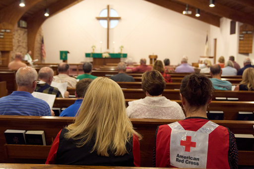 A woman wearing an American Red Cross shirt is seen during a service for the Sunday morning shooting at The Church of Jesus Christ of Latter-day Saints in Grand Blanc Township, Mich., Monday, Sept. 29, 2025. (AP Photo/Ryan Sun)