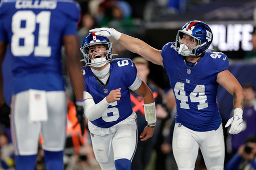 New York Giants' Jaxson Dart, center, and Cam Skattebo celebrate after a touchdown during the first half of an NFL football game against the Philadelphia Eagles Thursday, Oct. 9, 2025, in East Rutherford, N.J. (AP Photo/Adam Hunger)