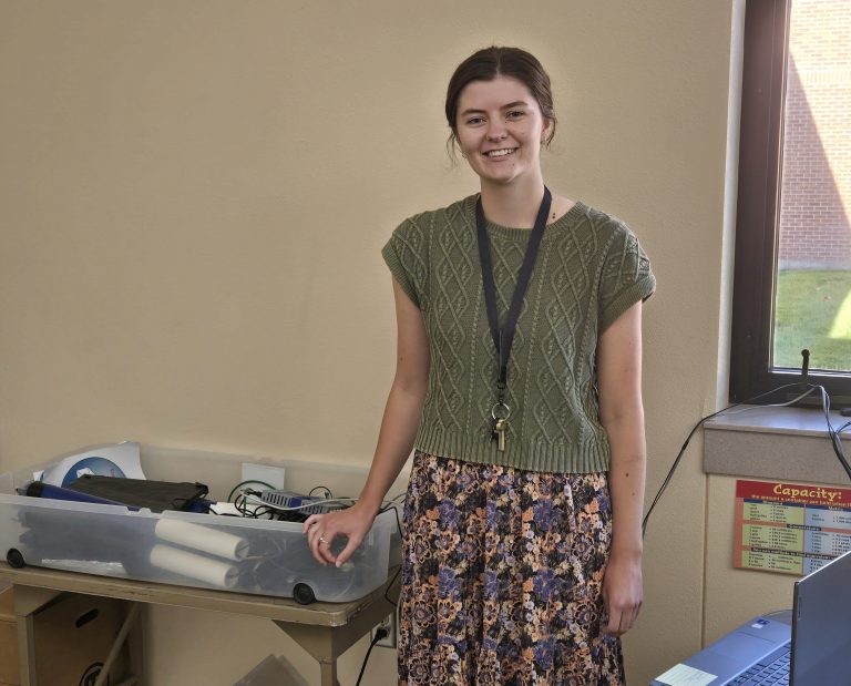Emily Siemonsma, in a classroom with scientific equipment provided though QuarkNet thanks to a donation from Nieman Enterprises.