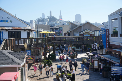 Visitors walk on the boardwalk at Fisherman's Wharf on Tuesday, Oct. 21, 2025, in San Francisco. (AP Photo/Jeff Chiu)