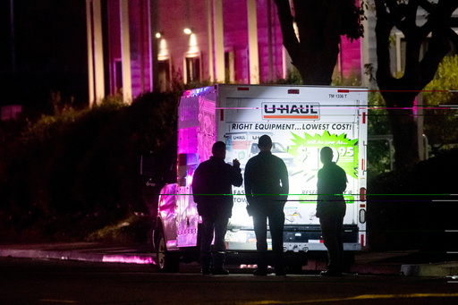 Police officers examine a U-Haul truck involved in a shooting at the entrance to Coast Guard Base Alameda, according to an officer at the scene, on Friday, Oct. 24, 2025, in Oakland, Calif. (AP Photo/Noah Berger)