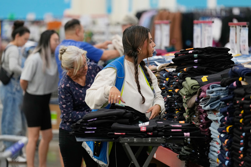 A worker stocks a display of clothing at a Sam's Club, Wednesday, Sept. 24, 2025, in Bentonville, Ark. (AP Photo/Charlie Riedel)