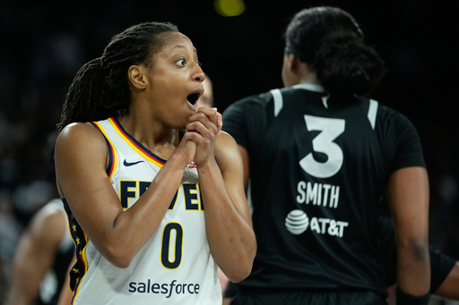 Indiana Fever guard Kelsey Mitchell (0) reacts after she was called for a foul against the Las Vegas Aces during the first half of Game 5 of a WNBA basketball playoff semifinals series Tuesday, Sept. 30, 2025, in Las Vegas. (AP Photo/John Locher)