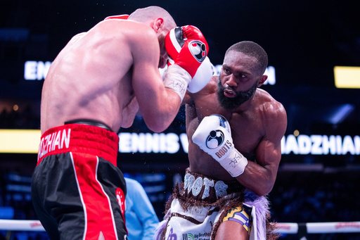FILE - Jaron Ennis, right, throws a punch at Karen Chukhadzhian, left, during the ninth round IBF World Welterweight title bout, Nov. 9, 2024, in Philadelphia. (AP Photo/Chris Szagola, File)