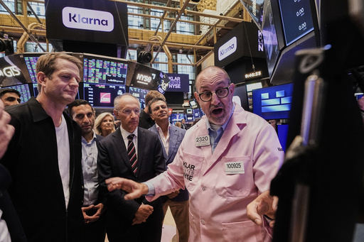Klarna CEO Sebastian Siemiatkowski, left and company Chairman Michael Moritz, center, meet with specialist Peter Giacchi, right, before their IPO begins trading on the floor of the New York Stock Exchange, Wednesday, Sept. 10, 2025. (AP Photo/Richard Drew)