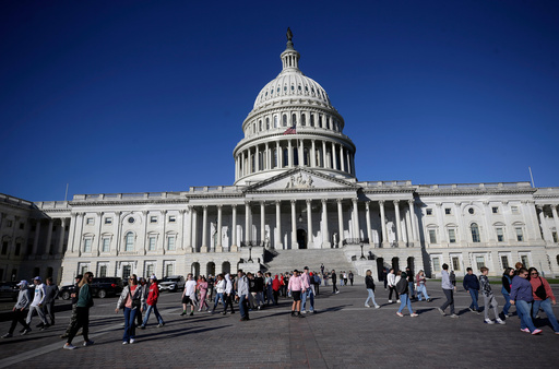 People walk on the East Front at the U.S. Capitol, Friday, Oct. 17, 2025, in Washington. (AP Photo/Rahmat Gul)