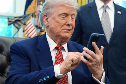 FILE - President Donald Trump silences his mobile phone in the Oval Office of the White House, May 23, 2025, in Washington. (AP Photo/Evan Vucci, File)