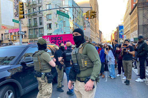 Federal agents conduct an immigration sweep on Canal Street in Chinatown as protestors gather, Tuesday, Oct. 21, 2025, in New York. (AP Photo/Jake Offenhartz)