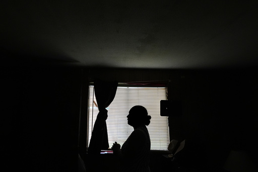 Paola Freites, who asked to be identified by her middle name and second last name to protect her family's safety, stands inside the two-bedroom mobile home where she lives with her husband and three children after fleeing persecution in their native Colombia, Thursday, Aug. 21, 2025, in Apopka, Fla. (AP Photo/Rebecca Blackwell)